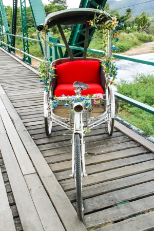 Vintage tricycle on Pai history bridge at Pai of Mae hong son Thailandの写真素材