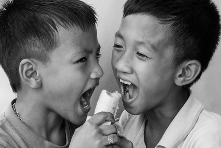 Two boy catching to eat banana.の写真素材
