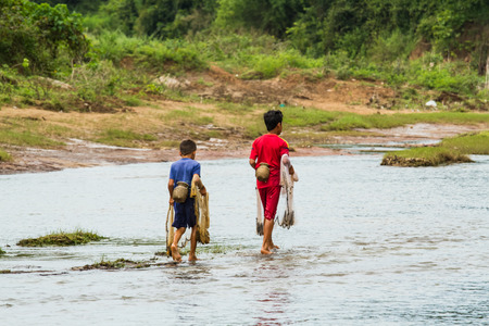 SAVANNAKHET,LAOS-OCTOBER 6 : The boy  ready to cast a net in the  river  at Savannakhet,Laos on October 6,2014.Cast a net is popular way to catch fish in Laos.の写真素材