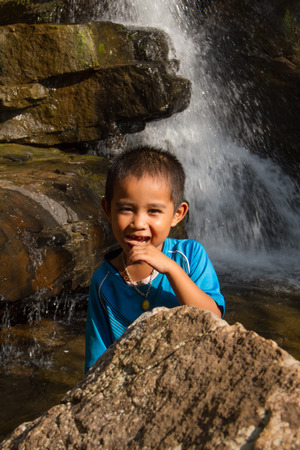 Asian boy enjoying at waterfall.の写真素材