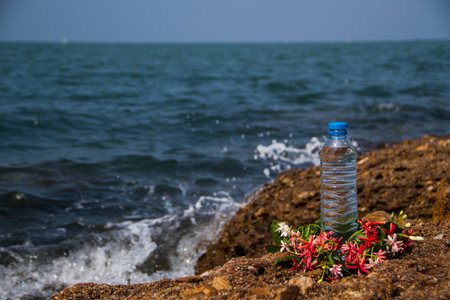 Drinking water bottle decorated with flowers  beside the sea.