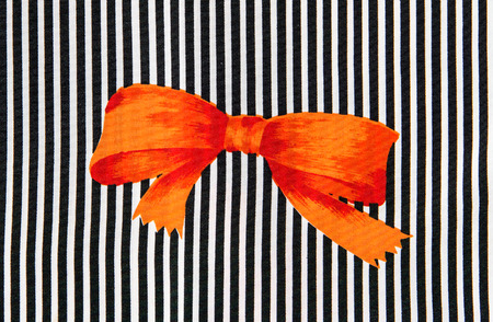 Orange bow on black and white strips.の写真素材