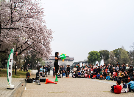 TOKYO,JAPAN-APRIL 1: Acrobat performance to the audience at Ueno park in Tokyo,Japan on April 1,2015.Street performer are all around in Tokyo.のeditorial素材