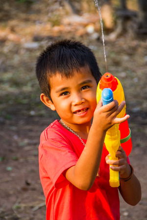 Boy shooting water gun in the summer time.の写真素材