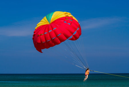 Tourist enjoy parasailing at Patong beach.