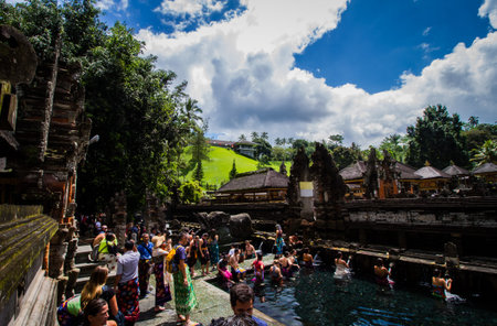 BALI,INDONESIA - AUGUST 19, 2016: Balinese Hindu and tourist  wash themselves in a ritual at the...
