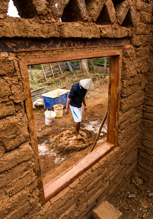 Builder mix ingredient of earthen house by feet.の写真素材