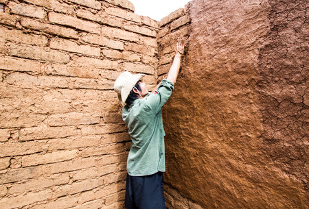 Builder plastering wall in earthen house.の写真素材