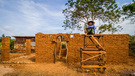 Builder sitting with earthen house background.の写真素材