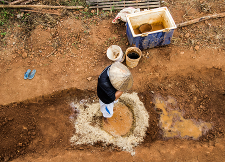 Builder mix ingredient of earthen house by feet.の写真素材