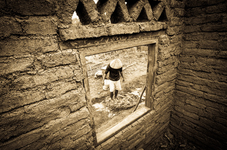 Builder mix ingredient of earthen house by feet.の写真素材