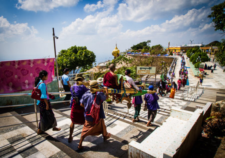 KYAIKTIYO,MYANMAR-MARCH 13,2017: The  tourists in a sedan chair - made of bamboo sticks with a folding wooden chair - being carried up the path to the Golden rock by Burmese men. The only two options to get to the top of Mt,Kyaiktiyo is to walk or hire a のeditorial素材