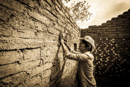 Builder plastering wall in earthen house.の写真素材