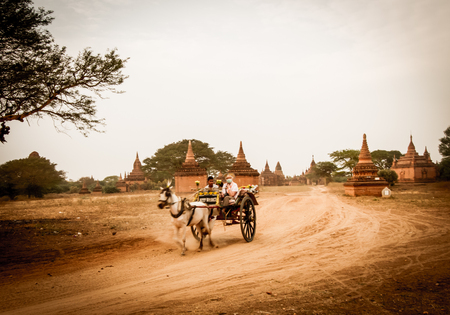 BAGAN,MYANMAR-MARCH 9:Tourist riding horse buggy to visiting ancient pagodas in Bagan,Myanmar on March 9,2017.Horse buggy is popular for tourist in Bagan.のeditorial素材