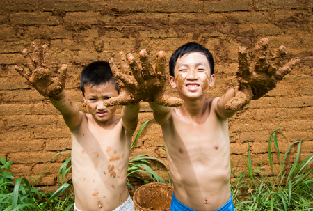The boy with dirty hand while  building mud house.の写真素材