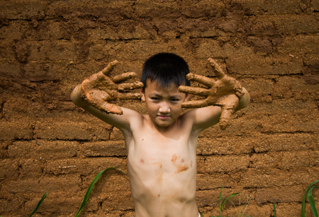 The boy with dirty hand while  building mud house.の写真素材