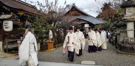KYOTO, JAPAN - NOVEMBER 25, 2019 : Kannushi men in white while praying ceremony at Kitano Tenmangu Shrine ,Kyoto.A kannushi mean "god master" who is a person responsible for the maintenance of a shinto shrine.のeditorial素材