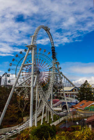 YAMANASHI,JAPANi - NOEMBER 24,2019: Unidentified fun people riding car on Roller coaster railway with Mount Fuji view and clear blue sky at Fuji-Q Highland amusement park.のeditorial素材
