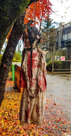 YAMANASHI, JAPAN - NOVEMBER 24,2019: ghost sculpture hanging on the tree in front of horror house at Fuji Q highland in  Yamanashi,Japan.This theme park have Mt.Fuji view background.のeditorial素材