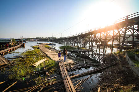 KANCHANABURI, THAILAND - DECEMBER 4, 2019 : Long wooden Mon bridge destroyed and damaged by stream of strong flood with temporary wooden bridge in Sangkhlaburi of Kanchanaburi, Thailandのeditorial素材