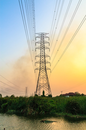 Electric power lines against blue and yellow skyの写真素材