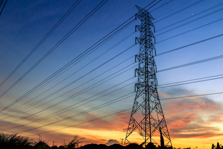 Line of electrical towers and power lines at sunset  Horizontal shot の写真素材