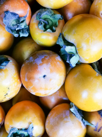 Large quantities of orange persimmons are on the store counter.の写真素材