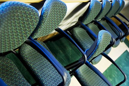 Standing out - one chair standing out in a row of office chairs - selective focus on 