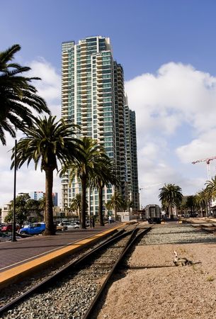 Train leaving San Diego station, with high-rise luxury condos and palm trees in the backgroundの写真素材