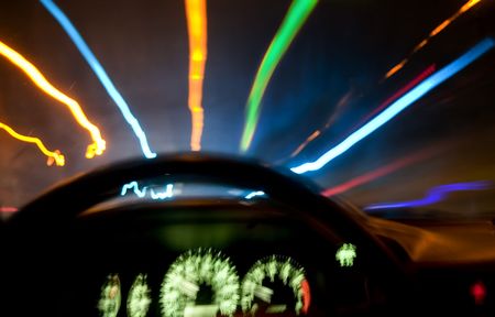 Long exposure photo from the driver's seat, with colorful street lights.  Car shake causing blur on the speedometerの写真素材