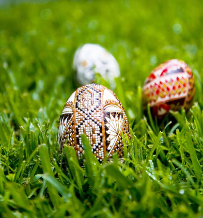 Traditional, wax decorated duck egg photographed on a  bed of dewey fresh grass.  Two more eggs in...