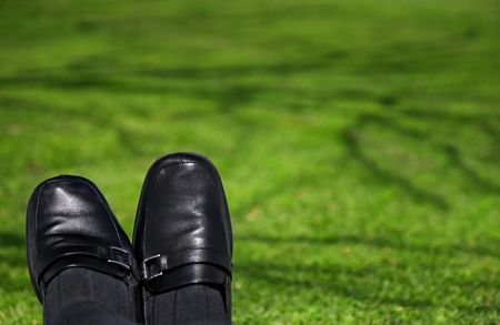 Feet of businessperson looking relaxed on a beautiful shaded lawn. Useful for freedom, vacation, "getting away from the grind" concepts.の写真素材