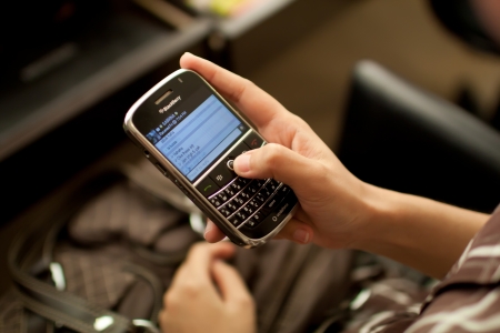 Woman using Blackberry Messenger to chat with her friend.のeditorial素材