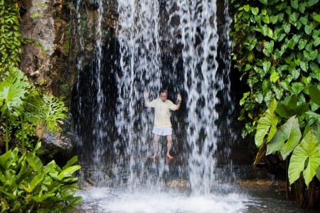 Senior chinese man practising taichi behind an artificial waterfall in Singapore Botanic Garden.のeditorial素材
