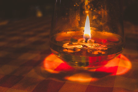 Romantic candle fire in a glass on a tablecloth.の写真素材
