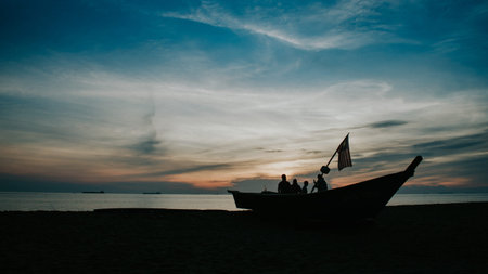 Silhouette of a fishing boat during sunset with beautiful skyscape.の写真素材