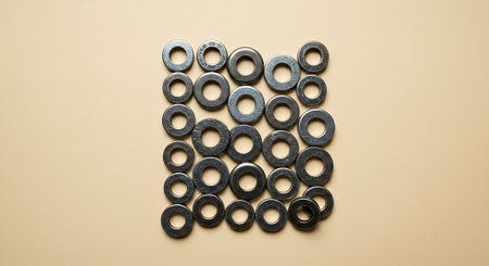 Metal nuts on a beige background. Top view. Flat lay.の素材
