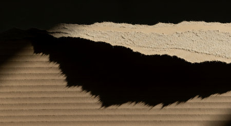 Torn paper on a black background with space for your text.の素材