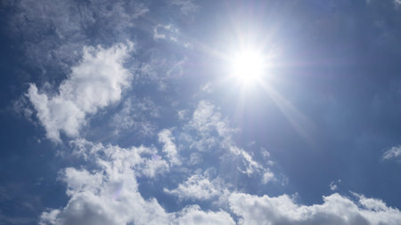 Rays of the sun in the blue sky and white clouds