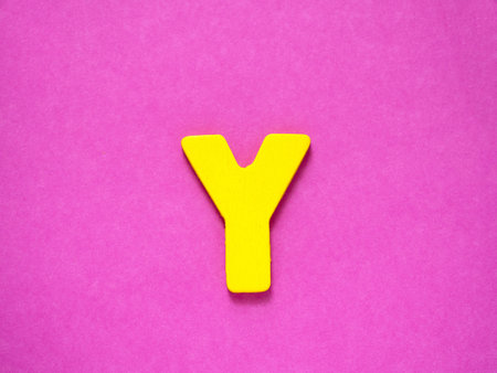 Capital letter Y. Yellow letter Y from wood on purple background.の写真素材