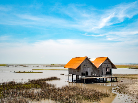 Perspective vintage local traditional old moldy hut in lake at talaynoi, Phatthalung Province, South of Thailand. Hut in the lake with beautiful blue sky. Countryside.の写真素材