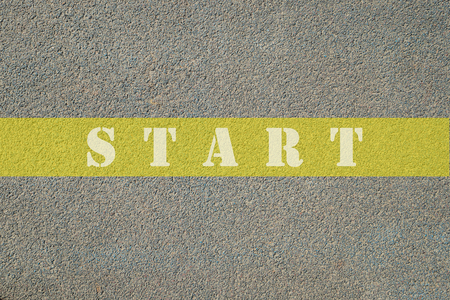 White start text written on yellow line on road with copy space for text. Concept of plan, target, goal, begin.の写真素材