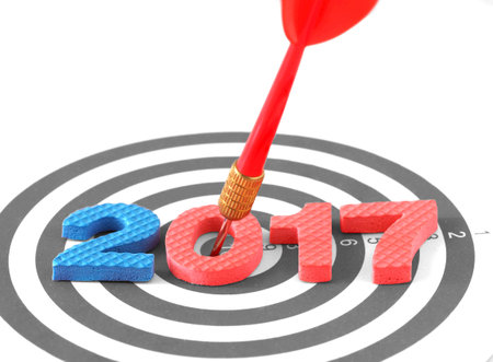 Year 2017 goal, two thousand seventeen with blur red bullseye dart arrow hitting target center...