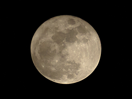 Full moon over dark black sky at nightの写真素材