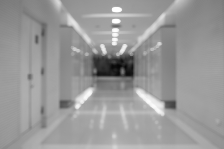 Black and white blurred long corridor in building with doors and reflections. Medical, hospital, office, hotel.の写真素材