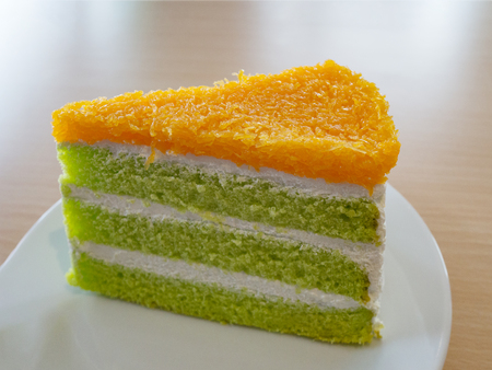 Delicious pandan and coconut cake with foi thong (golden threads Thai dessert) on white plate.の写真素材