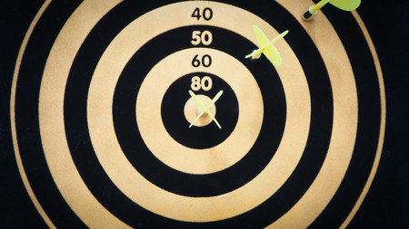 Black and yellow bullseye dart arrow hitting target center of dartboard. Concept of success, target, goal, achievement. (selective focus)の写真素材