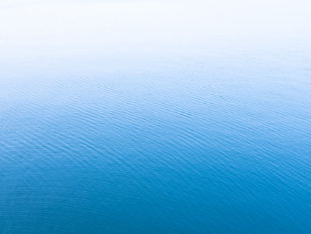 Unique blue background. Blue sea water surface texture background with white copy space on top.