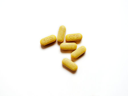 Expired yellow tablets vitamin C medicine on white background. Dangerous pills to use.