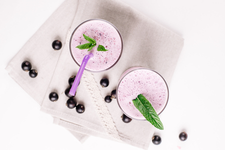 cold milkshake with a black currant on a white background, close-upの写真素材